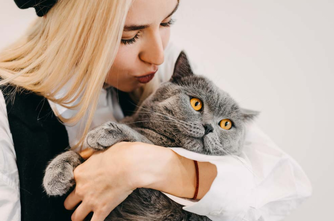 a woman kissing her cat