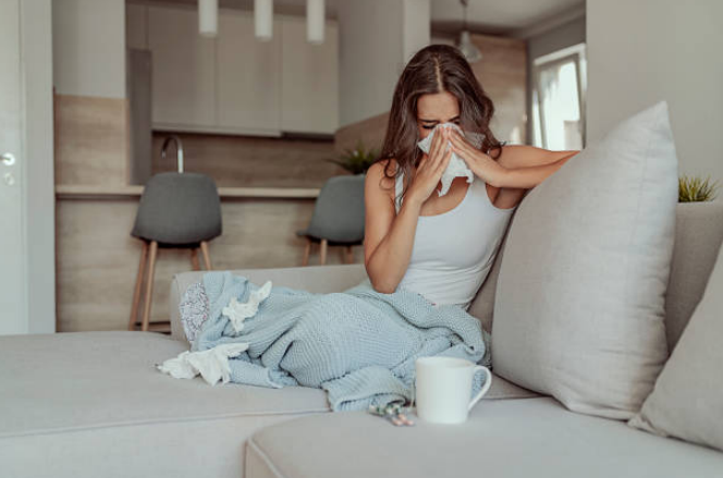 A woman sneezing into a tissue